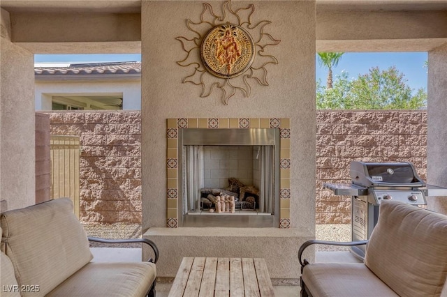 view of patio featuring a grill and a fireplace