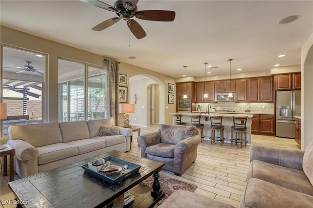 living room featuring ceiling fan and sink