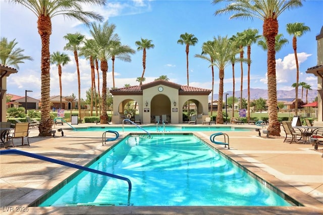 view of pool with a mountain view and a patio