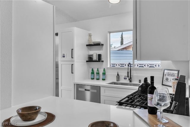 kitchen with white cabinets, light countertops, dishwasher, and a sink