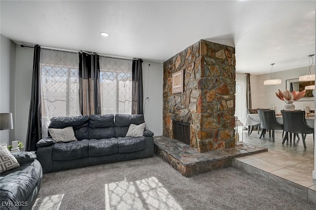 carpeted living room featuring a stone fireplace