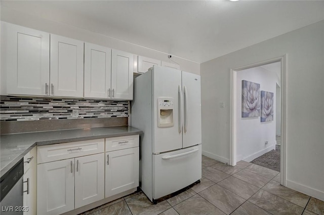 kitchen with dishwasher, white refrigerator with ice dispenser, decorative backsplash, light tile patterned floors, and white cabinetry