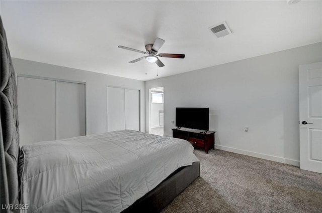 carpeted bedroom featuring ceiling fan and two closets