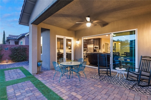 patio terrace at dusk featuring ceiling fan