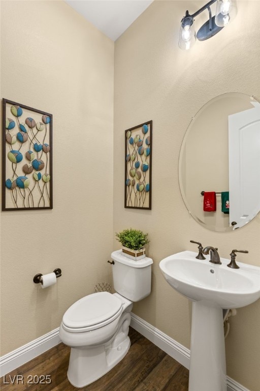 bathroom featuring hardwood / wood-style flooring and toilet