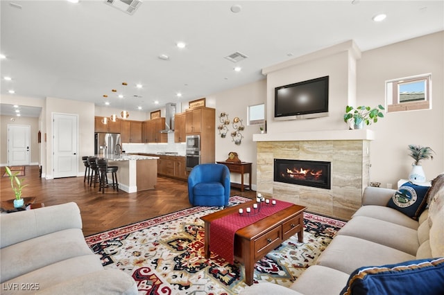 living room featuring dark parquet flooring and a tile fireplace