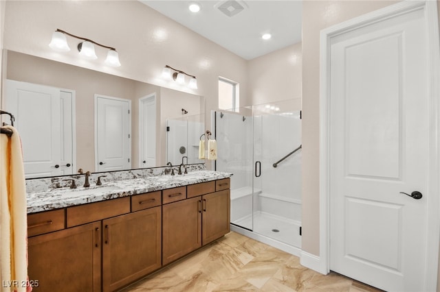 bathroom with vanity and a shower with door