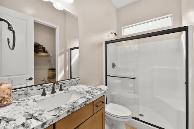 bathroom with vanity, toilet, and a shower with shower door