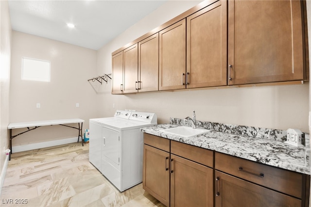 laundry room with washer and clothes dryer, sink, and cabinets