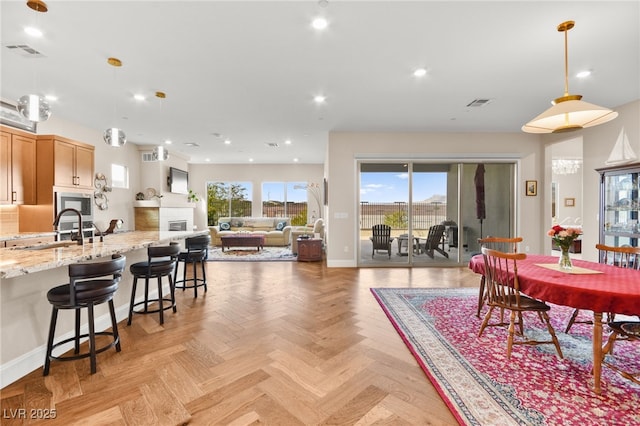 dining room featuring sink and light parquet flooring