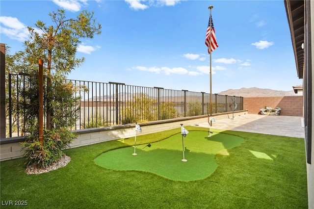 surrounding community with a mountain view and a patio