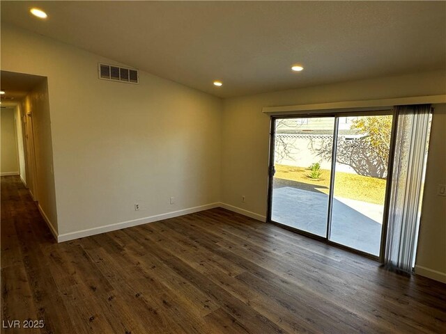 unfurnished room with vaulted ceiling and dark hardwood / wood-style floors