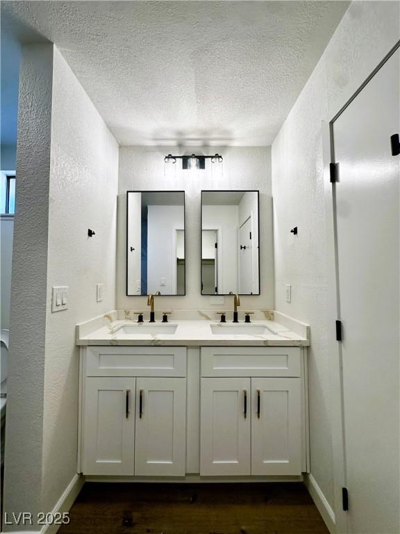 bathroom featuring hardwood / wood-style floors, vanity, and a textured ceiling