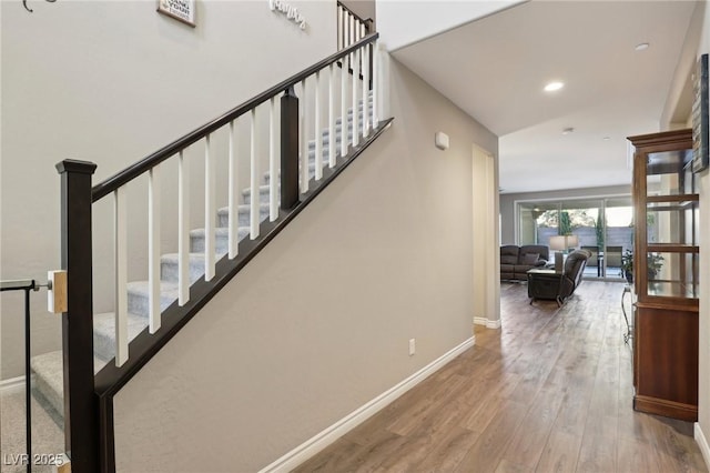 stairway featuring hardwood / wood-style floors and lofted ceiling