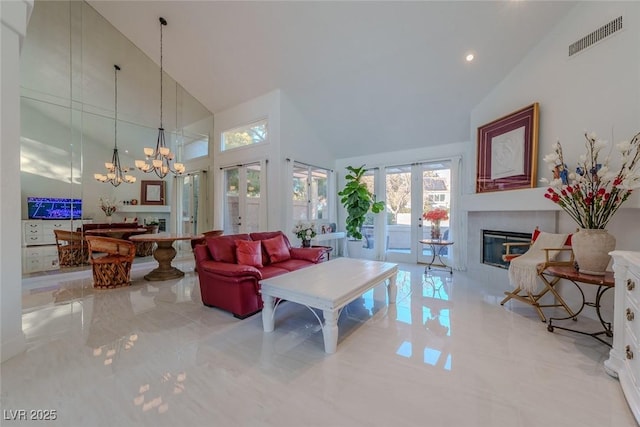 living room with high vaulted ceiling, french doors, and an inviting chandelier