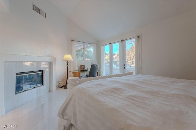 bedroom featuring vaulted ceiling, french doors, access to outside, and a tile fireplace