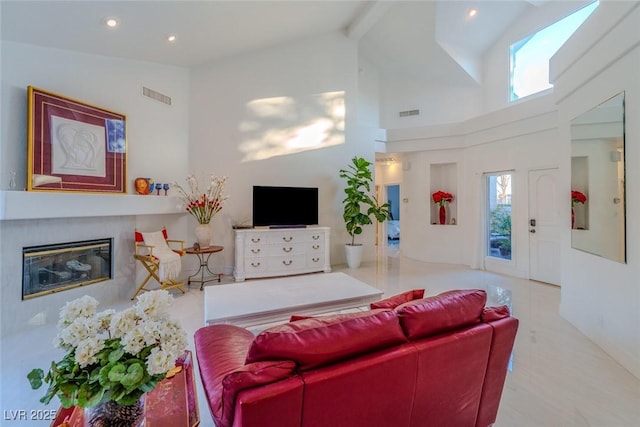 living room featuring beam ceiling and high vaulted ceiling