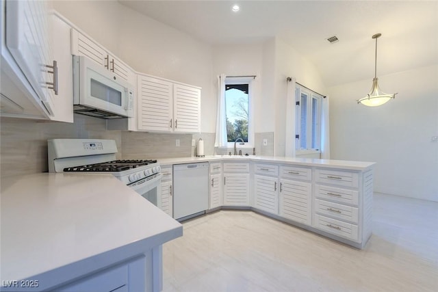 kitchen featuring decorative light fixtures, kitchen peninsula, sink, white appliances, and white cabinets