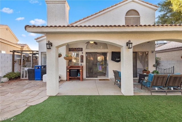 rear view of property with a patio area and ceiling fan