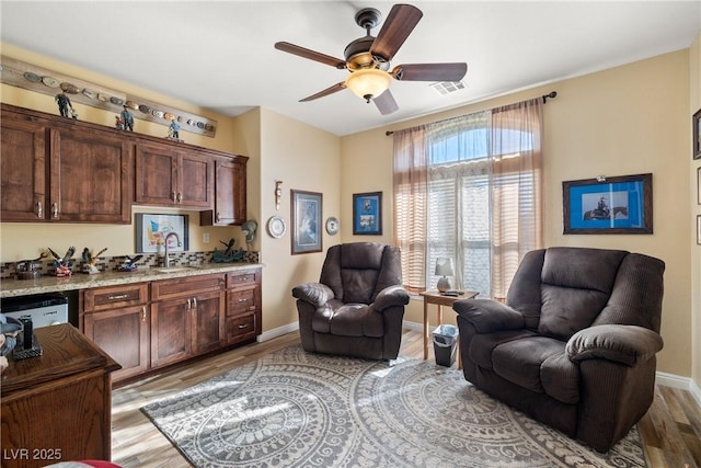 sitting room featuring ceiling fan, sink, and light hardwood / wood-style floors