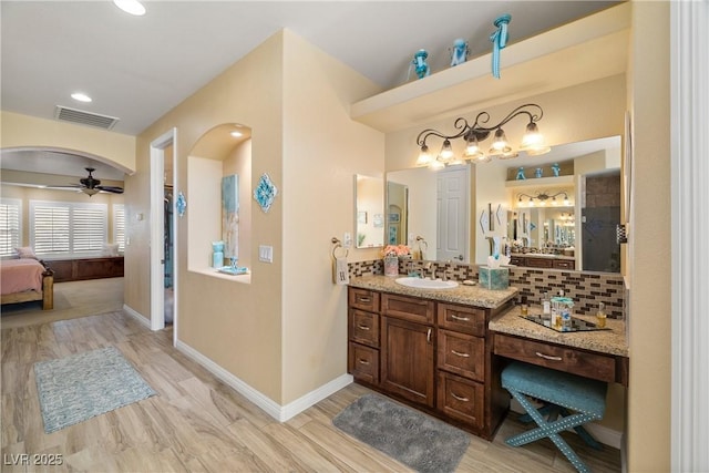 bathroom with tasteful backsplash, ceiling fan, vanity, and wood-type flooring