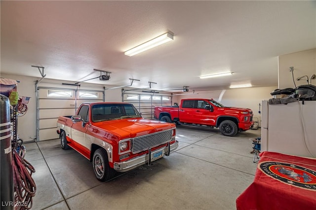 garage with white fridge and a garage door opener