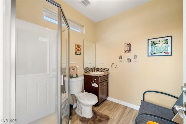 bathroom featuring a shower, vanity, wood-type flooring, and toilet