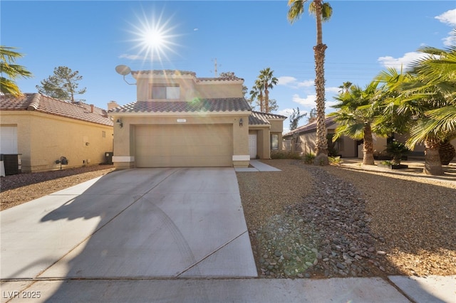 mediterranean / spanish house featuring a garage and central AC unit