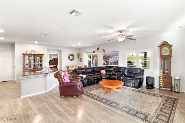 living room featuring ceiling fan and light wood-type flooring