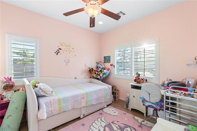 bedroom featuring multiple windows, ceiling fan, and light hardwood / wood-style flooring