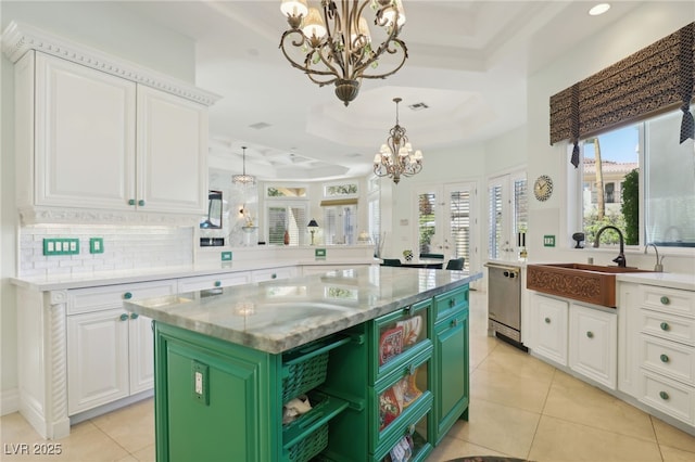 kitchen featuring a center island, a raised ceiling, sink, and green cabinetry