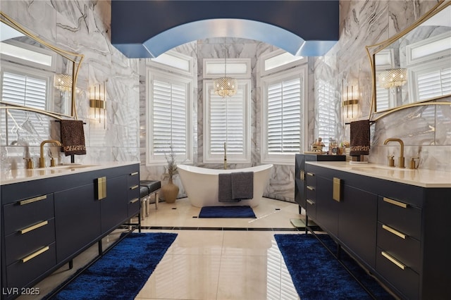 bathroom featuring a washtub, vanity, a chandelier, and tile patterned flooring