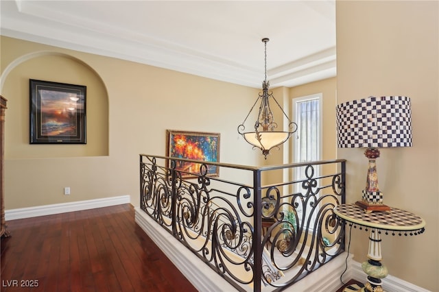 hallway featuring a tray ceiling and dark wood-type flooring