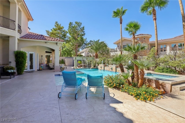 view of swimming pool featuring an in ground hot tub and a patio