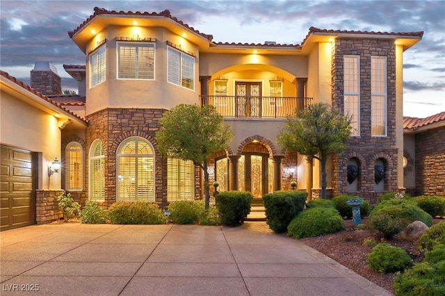 mediterranean / spanish home with a garage and a balcony