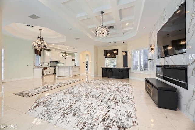 living room with beamed ceiling, a raised ceiling, and coffered ceiling