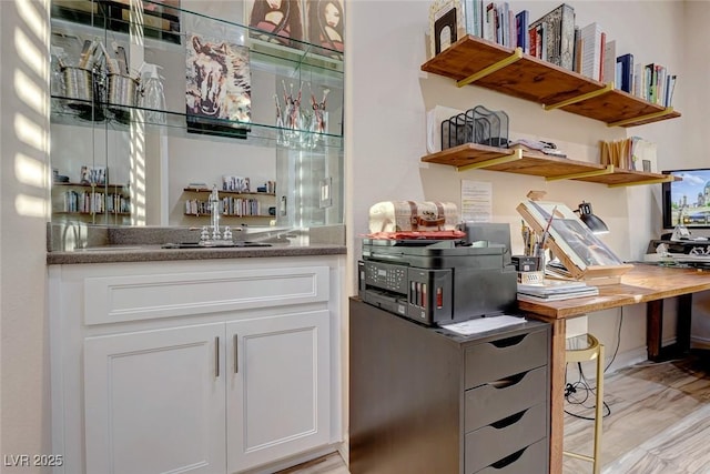 interior space featuring white cabinets, sink, and light hardwood / wood-style flooring