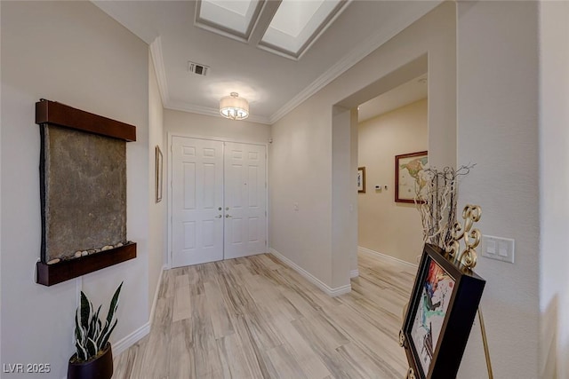 entrance foyer with light hardwood / wood-style floors and crown molding