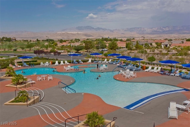 view of swimming pool featuring a mountain view and a patio