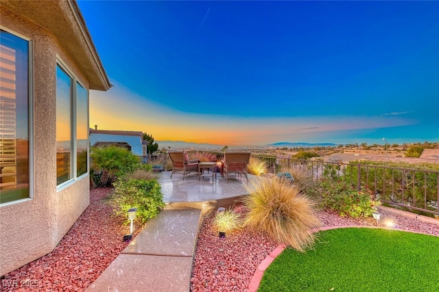 yard at dusk with an outdoor hangout area and a patio area