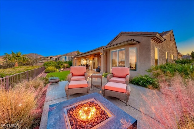 patio terrace at dusk featuring an outdoor fire pit