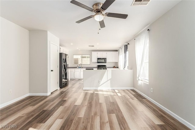 unfurnished living room with light hardwood / wood-style flooring, ceiling fan, and sink