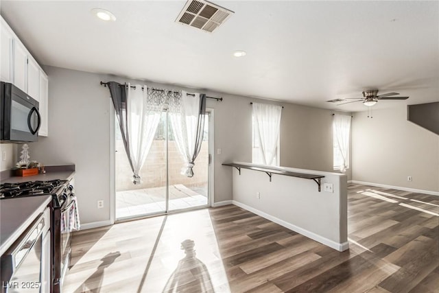 kitchen featuring ceiling fan, white cabinets, dark wood-type flooring, and appliances with stainless steel finishes