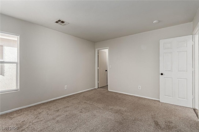 spare room featuring light carpet