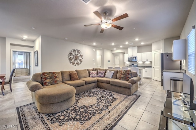 tiled living room with ceiling fan