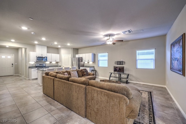 living room featuring ceiling fan and light tile patterned floors