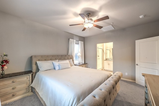 bedroom featuring ensuite bath, light colored carpet, and ceiling fan