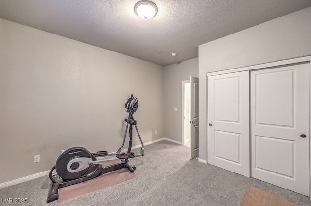 exercise room with carpet floors and a textured ceiling