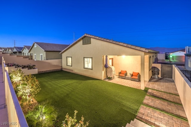 rear view of house featuring an outdoor living space, a patio, and a lawn