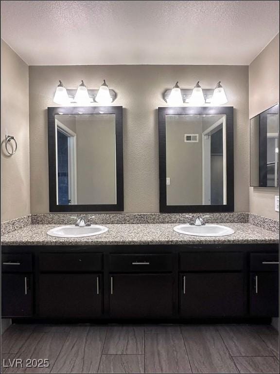 bathroom featuring a textured ceiling and vanity